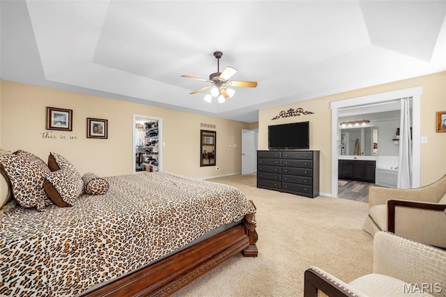 7742 Ardmore Dr, Ofallon, MO 63368 - bedroom with a tray ceiling, light carpet, ensuite bath, a ceiling fan, and a walk in closet