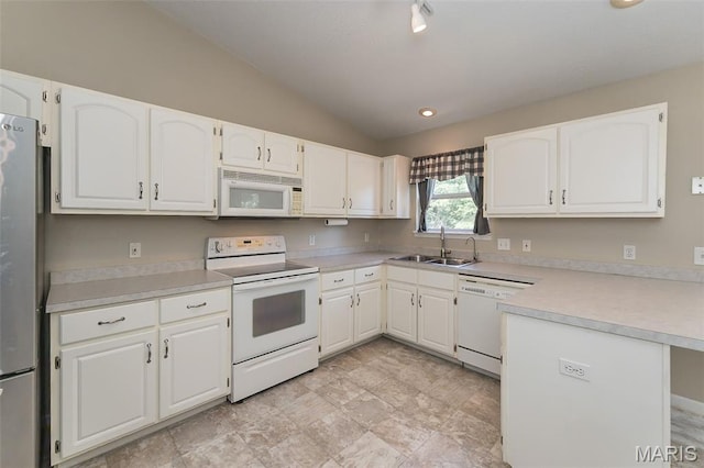 563 Great Plains Dr, House Springs, MO 63051 - kitchen featuring white appliances, lofted ceiling, white cabinetry, light countertops, and a peninsula