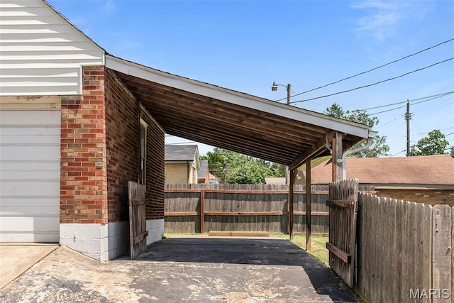 6736 Julian Ave, University City, MO 63130 - view of patio with an attached carport and asphalt driveway