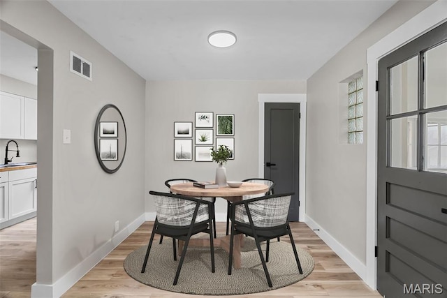 6736 Julian Ave, University City, MO 63130 - dining room featuring baseboards and light wood-style flooring