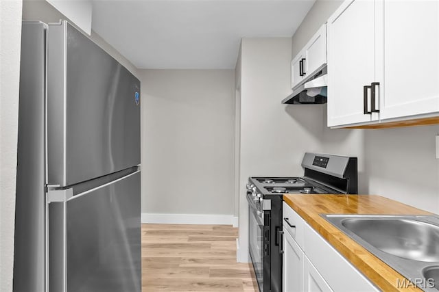 6736 Julian Ave, University City, MO 63130 - kitchen featuring stainless steel appliances, under cabinet range hood, wood counters, light wood-type flooring, and white cabinets