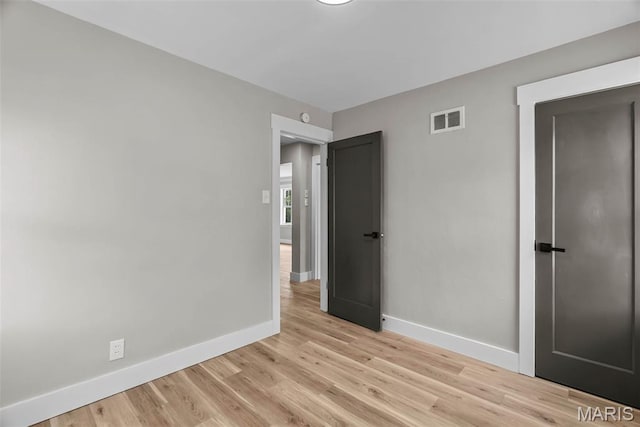 6736 Julian Ave, University City, MO 63130 - unfurnished bedroom with baseboards and light wood-style floors
