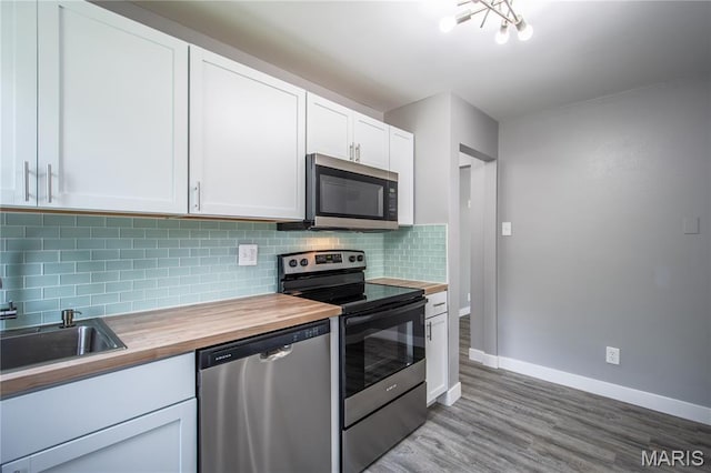 1900 Owen Dr, Hanley Hills, MO 63133 - kitchen with stainless steel appliances, wood counters, backsplash, light wood finished floors, and white cabinets