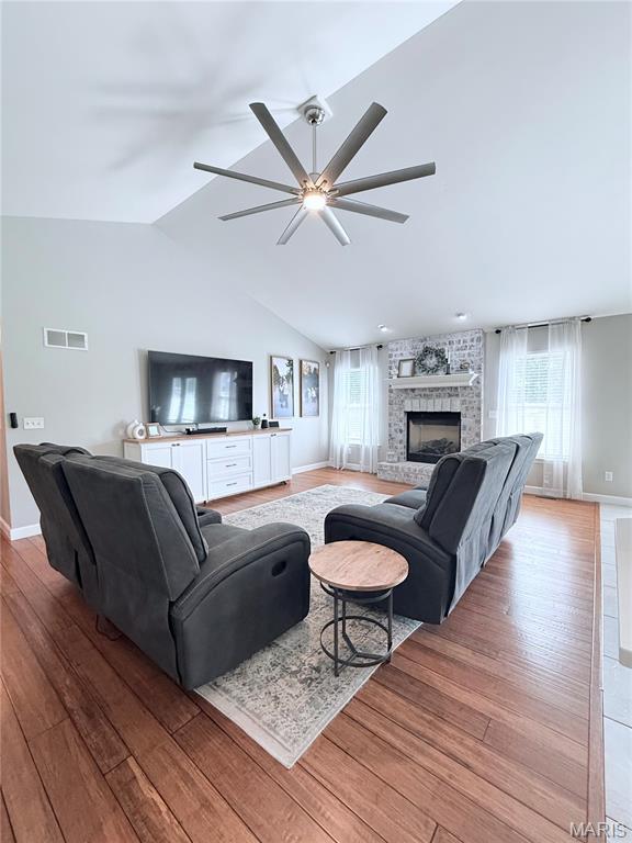 2354 Fountain Dr, Barnhart, MO 63012 - living room with a ceiling fan, healthy amount of natural light, wood finished floors, vaulted ceiling, and a brick fireplace