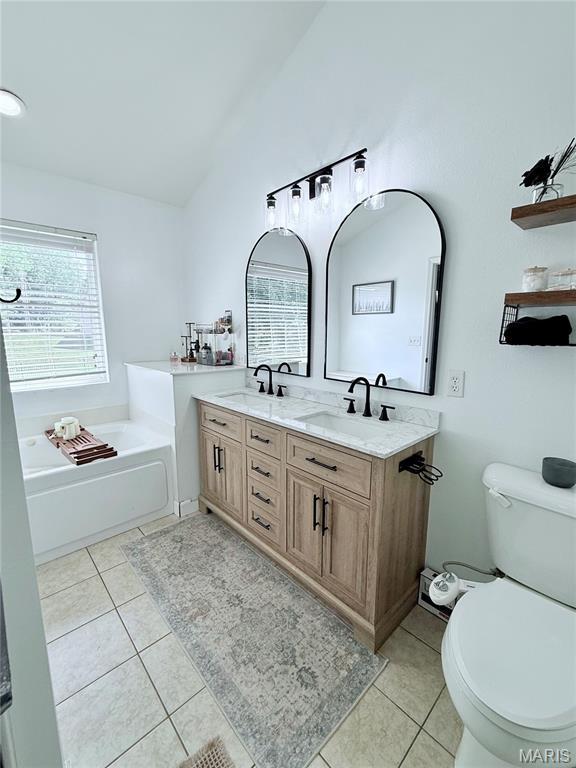 2354 Fountain Dr, Barnhart, MO 63012 - full bath featuring healthy amount of natural light, a garden tub, double vanity, tile patterned floors, and vaulted ceiling