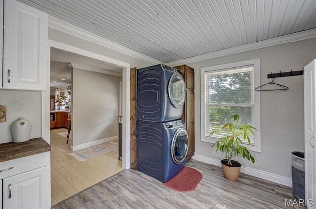 10317 Mallard Rd, Potosi, MO 63664 - washroom with stacked washing machine and dryer, crown molding, and light wood-style floors