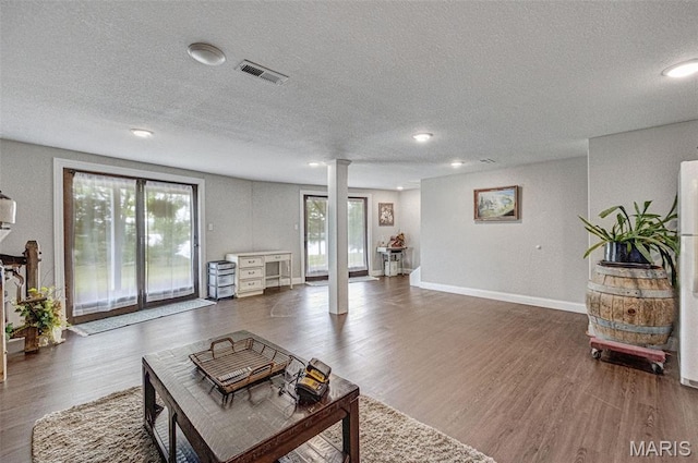 10317 Mallard Rd, Potosi, MO 63664 - living area featuring decorative columns, dark wood-style flooring, a textured ceiling, and recessed lighting