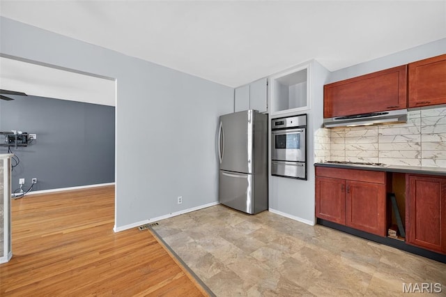 10564 Mert Ave, Saint Ann, MO 63074 - kitchen with appliances with stainless steel finishes, under cabinet range hood, a warming drawer, and decorative backsplash