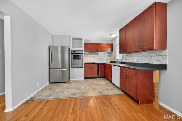 10564 Mert Ave, Saint Ann, MO 63074 - kitchen with stainless steel appliances, a warming drawer, backsplash, light wood-type flooring, and dark countertops