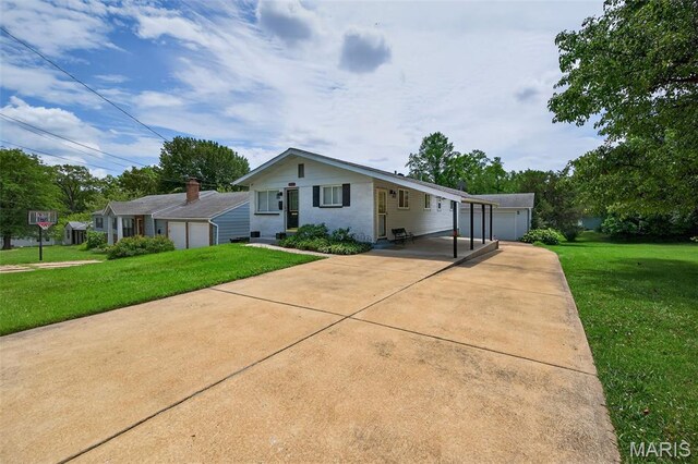 10564 Mert Ave, Saint Ann, MO 63074 - view of front of house with a front lawn, a garage, an outbuilding, and a carport