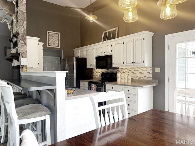 885 Oak Pass Ln, Sullivan, MO 63080 - kitchen featuring stainless steel appliances, tasteful backsplash, white cabinetry, a peninsula, and a kitchen bar