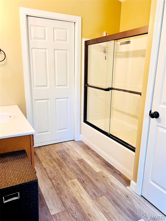 885 Oak Pass Ln, Sullivan, MO 63080 - bathroom featuring wood finished floors, combined bath / shower with glass door, and vanity