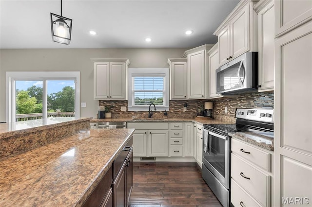 255 Sassenach Dr, Jackson, MO 63755 - kitchen with appliances with stainless steel finishes, dark wood-style flooring, decorative backsplash, light stone countertops, and white cabinets