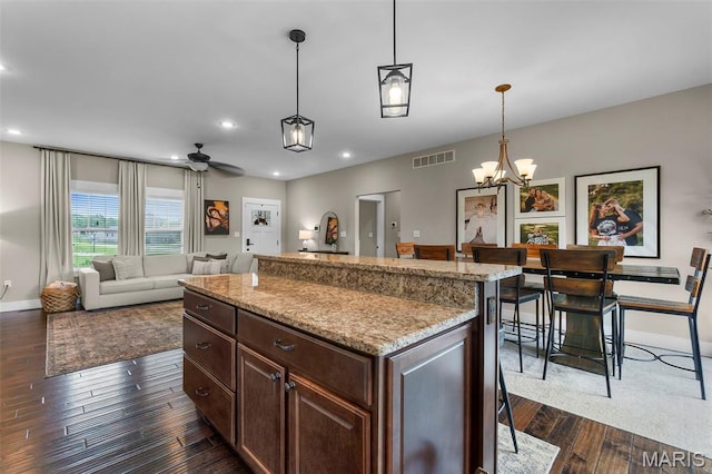 255 Sassenach Dr, Jackson, MO 63755 - kitchen with dark wood-style floors, a chandelier, decorative light fixtures, light stone countertops, and recessed lighting