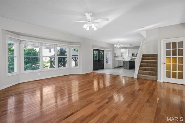 2849 Dardenne Links Dr, Dardenne Prairie, MO 63368 - unfurnished living room with a chandelier, ceiling fan, wood finished floors, and stairs