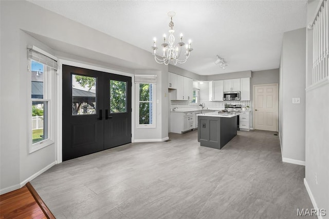 2849 Dardenne Links Dr, Dardenne Prairie, MO 63368 - kitchen with stainless steel microwave, a chandelier, range, white cabinets, and light countertops