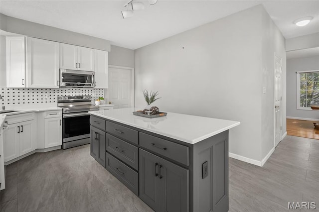 2849 Dardenne Links Dr, Dardenne Prairie, MO 63368 - kitchen with stainless steel appliances, gray cabinets, white cabinetry, and light countertops