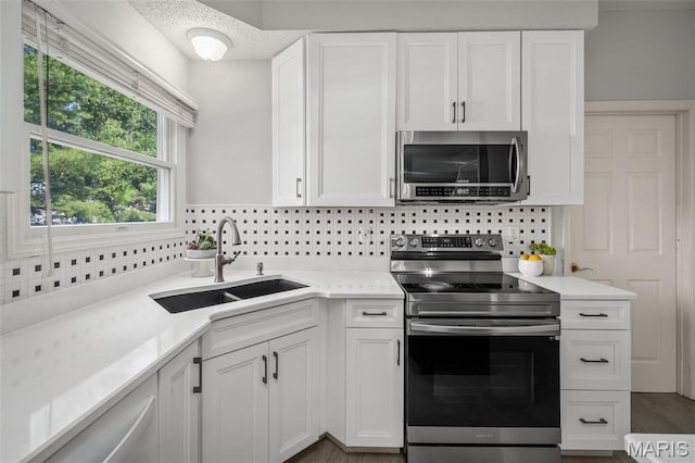 2849 Dardenne Links Dr, Dardenne Prairie, MO 63368 - kitchen featuring stainless steel appliances, backsplash, light countertops, and white cabinets