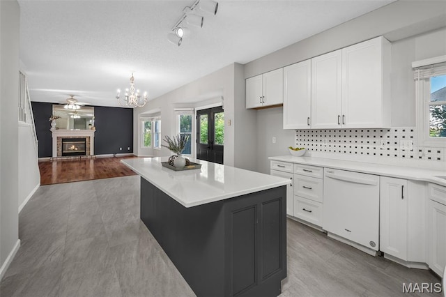 2849 Dardenne Links Dr, Dardenne Prairie, MO 63368 - kitchen featuring white dishwasher, white cabinetry, light countertops, tasteful backsplash, and open floor plan