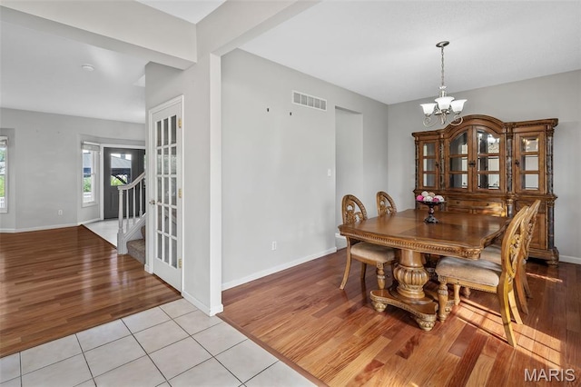 2849 Dardenne Links Dr, Dardenne Prairie, MO 63368 - dining space featuring a chandelier, light wood-style flooring, and stairs