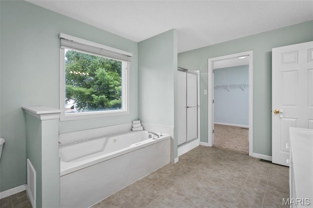 2849 Dardenne Links Dr, Dardenne Prairie, MO 63368 - full bath with a stall shower, a garden tub, a walk in closet, and a textured ceiling
