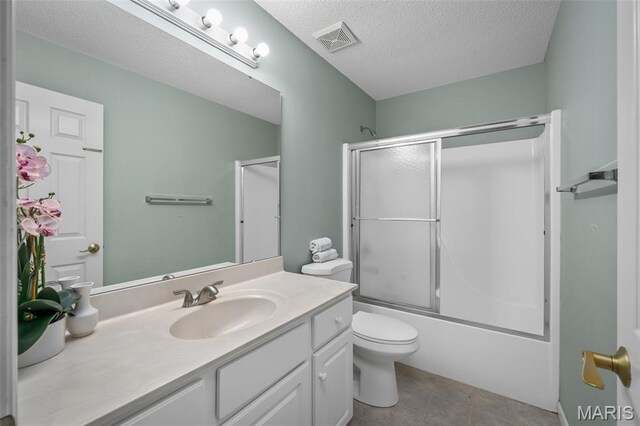 2849 Dardenne Links Dr, Dardenne Prairie, MO 63368 - bathroom with vanity, a textured ceiling, combined bath / shower with glass door, and tile patterned flooring
