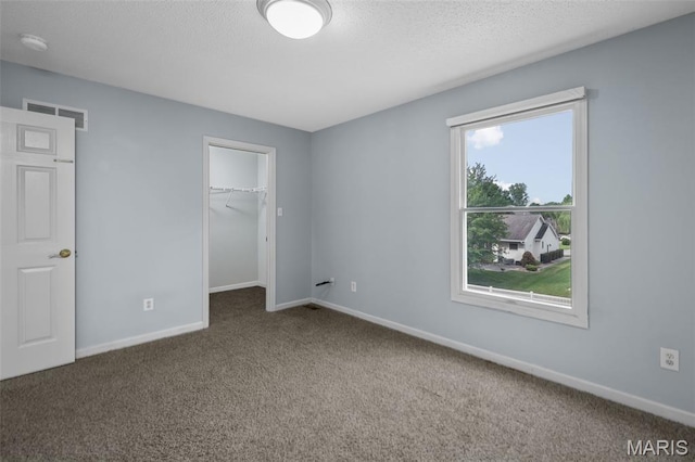 2849 Dardenne Links Dr, Dardenne Prairie, MO 63368 - unfurnished bedroom with carpet flooring, a walk in closet, and a textured ceiling