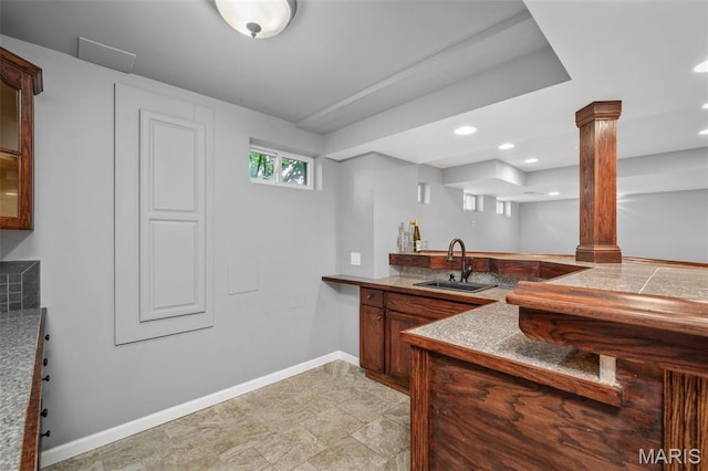 2849 Dardenne Links Dr, Dardenne Prairie, MO 63368 - kitchen with decorative columns, recessed lighting, glass insert cabinets, a peninsula, and brown cabinets