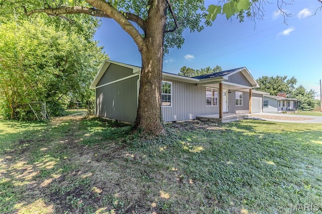 1507 Finn Dr, Lebanon, MO 65536 - view of front of house with a front lawn, board and batten siding, covered porch, and an attached garage