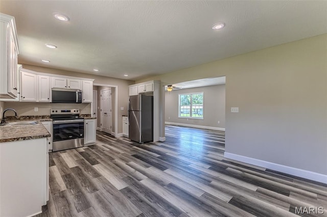 1507 Finn Dr, Lebanon, MO 65536 - kitchen with stainless steel appliances, white cabinetry, dark wood-style floors, ceiling fan, and recessed lighting