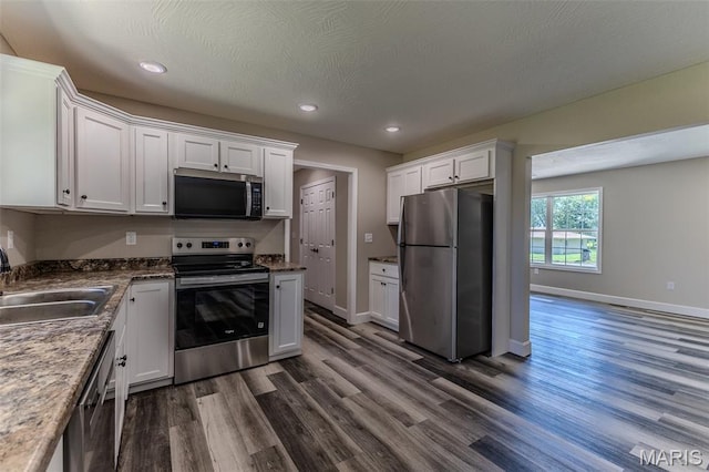1507 Finn Dr, Lebanon, MO 65536 - kitchen featuring stainless steel appliances, white cabinets, dark wood-type flooring, and recessed lighting