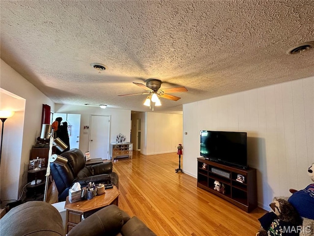 918 E 7th St, Rolla, MO 65401 - living room with light wood finished floors, a ceiling fan, and a textured ceiling