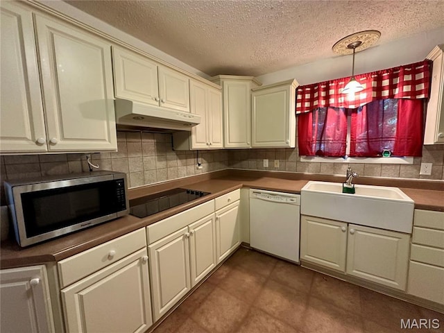 918 E 7th St, Rolla, MO 65401 - kitchen featuring dishwasher, stainless steel microwave, under cabinet range hood, black electric stovetop, and a textured ceiling