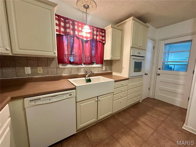 918 E 7th St, Rolla, MO 65401 - kitchen with white appliances, tasteful backsplash, a textured ceiling, decorative light fixtures, and dark flooring