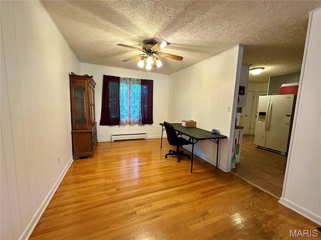 918 E 7th St, Rolla, MO 65401 - home office with a baseboard radiator, light wood finished floors, a textured ceiling, and ceiling fan