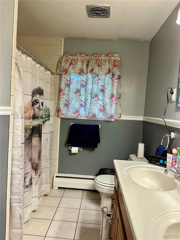 918 E 7th St, Rolla, MO 65401 - full bath featuring a baseboard radiator, tile patterned flooring, double vanity, and a shower with curtain