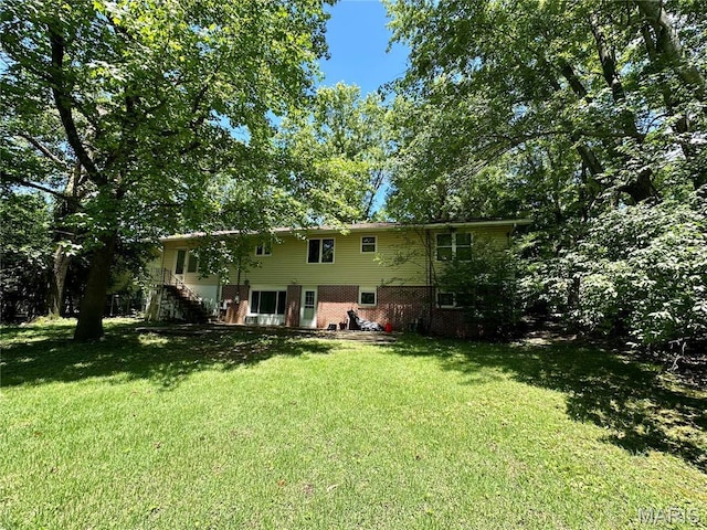 918 E 7th St, Rolla, MO 65401 - rear view of house featuring stairs, a lawn, and brick siding