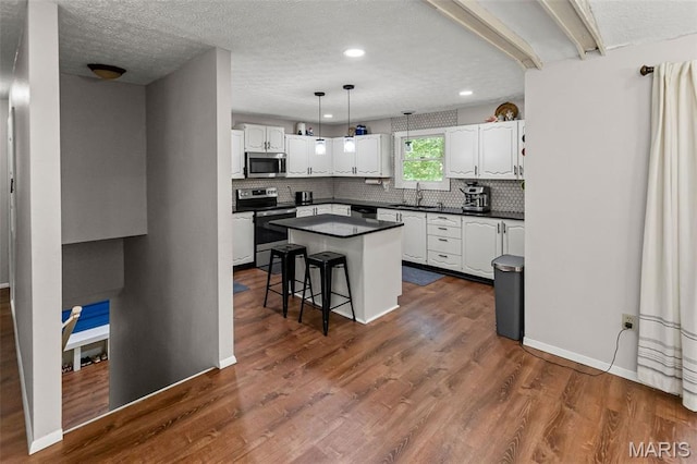 1716 Fountainbleu Dr, Worden, IL 62097 - kitchen with stainless steel appliances, dark countertops, white cabinets, tasteful backsplash, and a textured ceiling