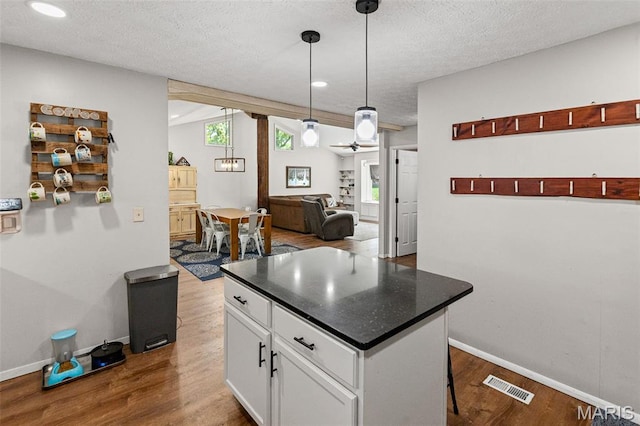 1716 Fountainbleu Dr, Worden, IL 62097 - kitchen with dark wood finished floors, white cabinetry, dark countertops, a center island, and a textured ceiling