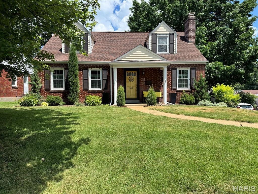 35 Holly Dr, Webster Groves, MO 63119 - cape cod-style house featuring a front lawn, a chimney, brick siding, and roof with shingles