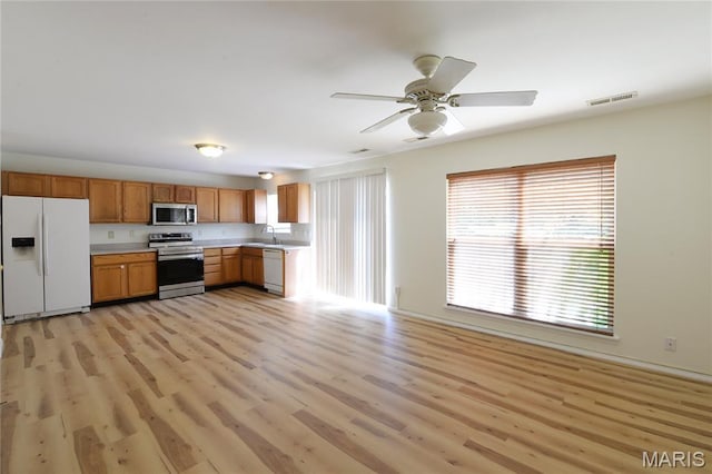 154 Homeshire Dr Unit 27, Wentzville, MO 63385 - kitchen with stainless steel appliances, light countertops, light wood-style flooring, ceiling fan, and brown cabinets