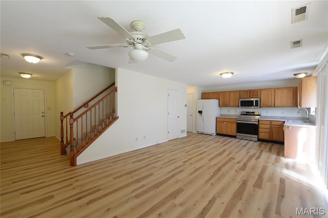 154 Homeshire Dr Unit 27, Wentzville, MO 63385 - kitchen with appliances with stainless steel finishes, light wood-type flooring, light countertops, and brown cabinetry