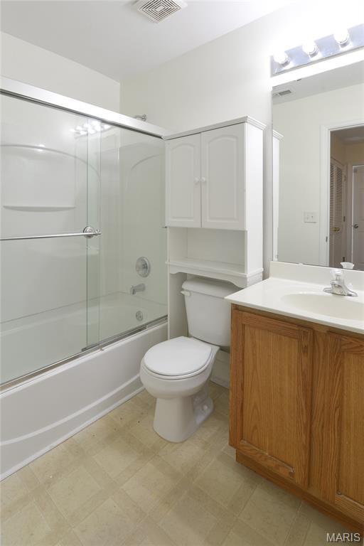 154 Homeshire Dr Unit 27, Wentzville, MO 63385 - bathroom featuring vanity, enclosed tub / shower combo, and tile patterned floors