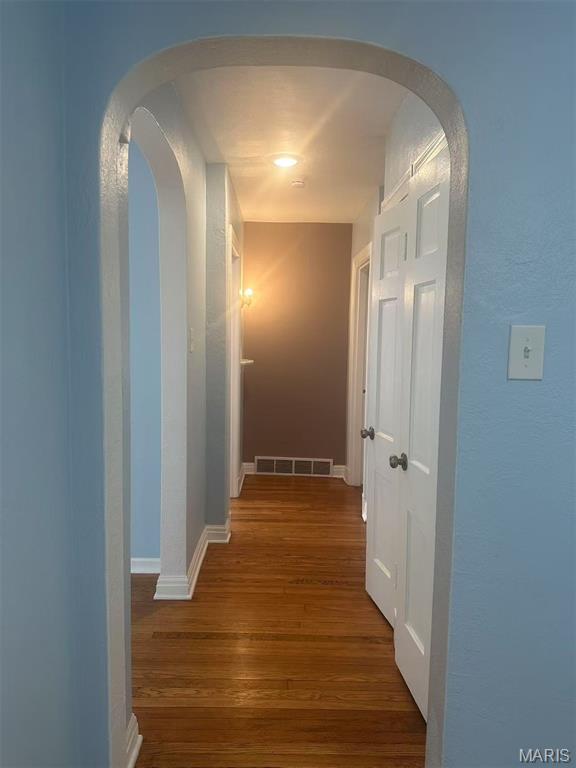 3525 Belaire Pl, Beverly Hills, MO 63121 - hallway featuring wood finished floors and arched walkways