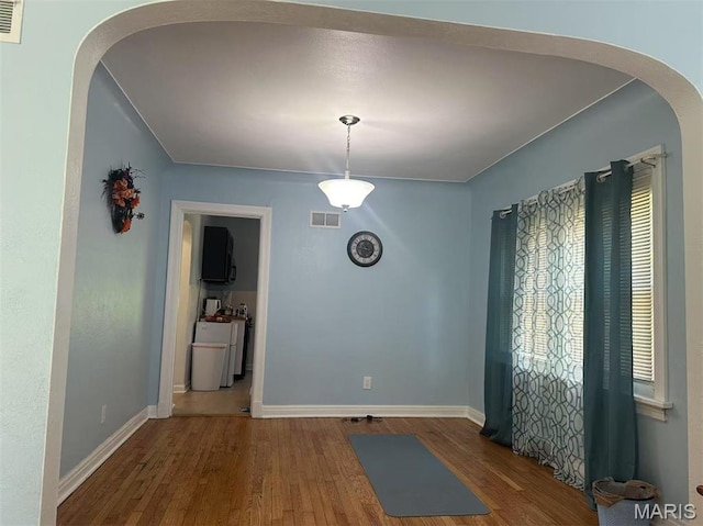 3525 Belaire Pl, Beverly Hills, MO 63121 - unfurnished dining area with wood finished floors and arched walkways