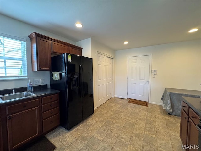 5037 Bristol Hill Dr, Ofallon, IL 62269 - kitchen with black fridge, dark countertops, recessed lighting, and dark brown cabinets