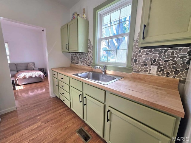 315 W State St, Union, MO 63084 - kitchen with green cabinets, wooden counters, light wood-style flooring, and backsplash
