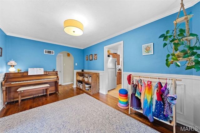 100 Calverton Rd, Saint Louis, MO 63135 - bedroom with freestanding refrigerator, arched walkways, wood finished floors, a wainscoted wall, and crown molding