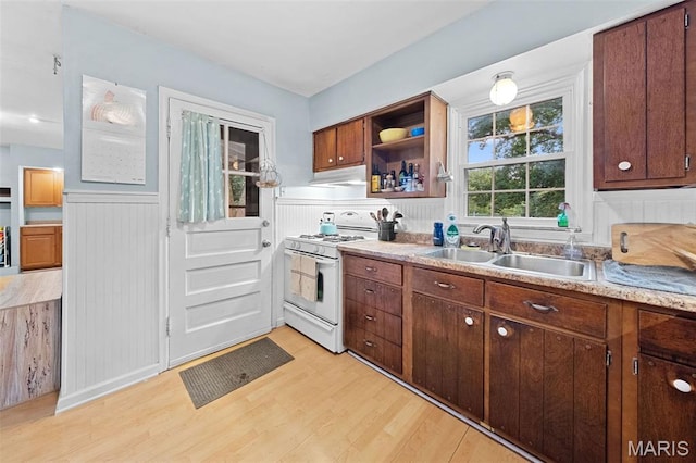 100 Calverton Rd, Saint Louis, MO 63135 - kitchen featuring white gas range, under cabinet range hood, light wood-type flooring, light countertops, and a wainscoted wall