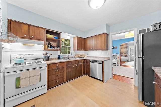 100 Calverton Rd, Saint Louis, MO 63135 - kitchen featuring appliances with stainless steel finishes, under cabinet range hood, light wood finished floors, arched walkways, and brown cabinets